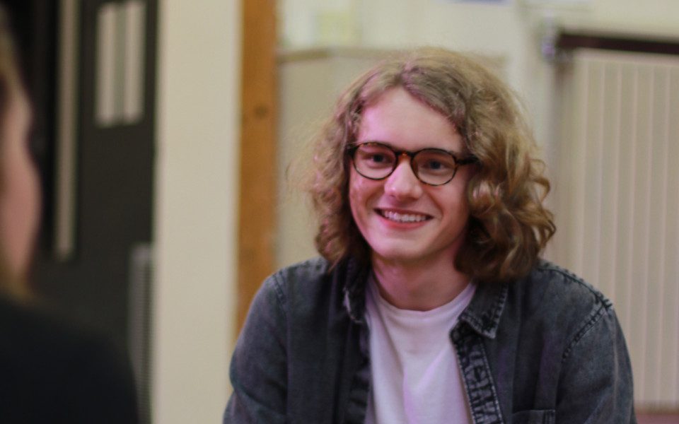 16-year-old Gabriel Owens smiling. He wears glasses and has long blonde hair.