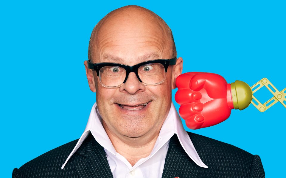 Harry Hill being punched by a retractable arm and boxing glove
