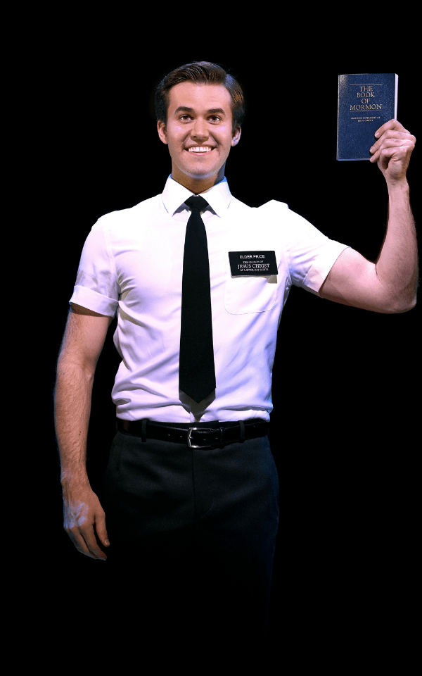 Kevin Clay wearing white shirt and black tie holding The Book of Mormon with his left hand