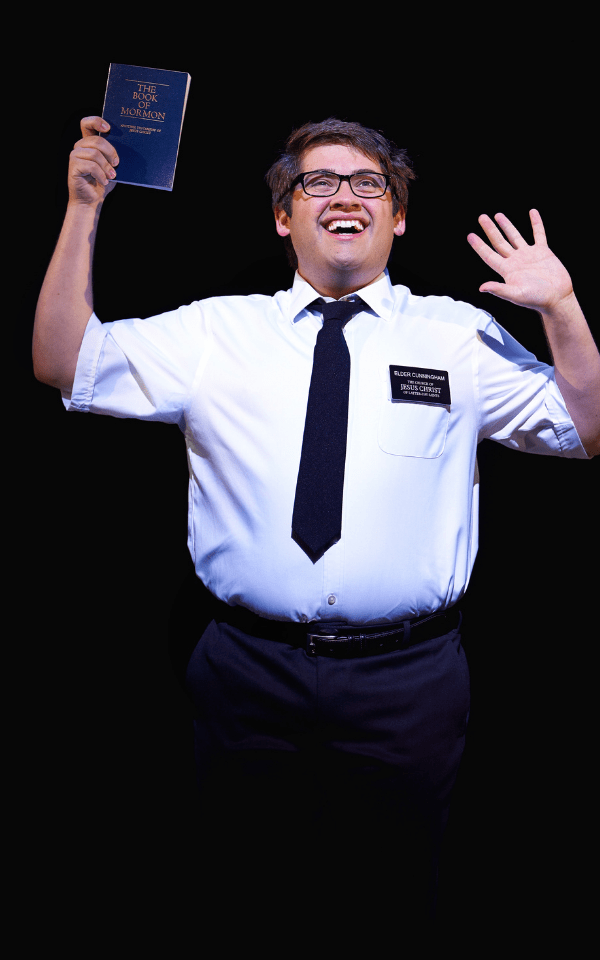 Conner Peirson wearing white shirt and black tie holding the Book of Mormon in his right hand
