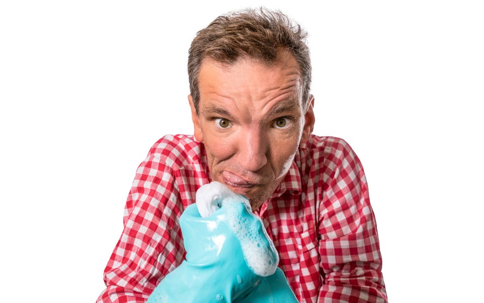 Henning Wehn with rubber washing up gloves covered in soap suds pulling a funny face