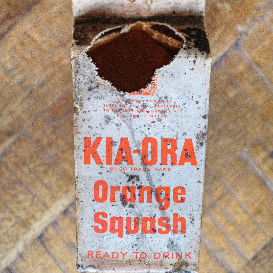 An old Kia Ora Orange Squash carton with orange writing on white cardboard