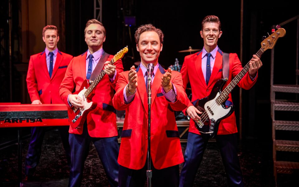 The cast of Jersey Boys in their iconic red suits
