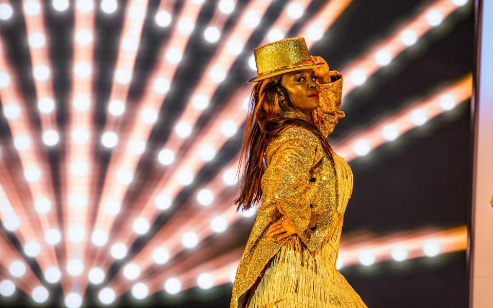 Oti Mabuse in a gold jacket and top hat