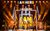 Oti Mabuse I Am Here Oti Mabuse and her dancers on stage in front of big gold and white letters says I Am Here four times