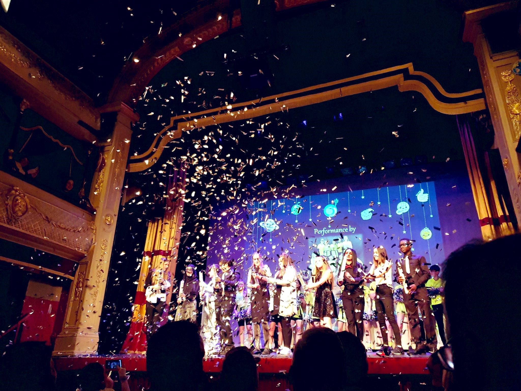 Young people on stage with a confetti canon