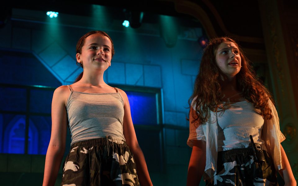 Two young people on stage in front of blue lighting