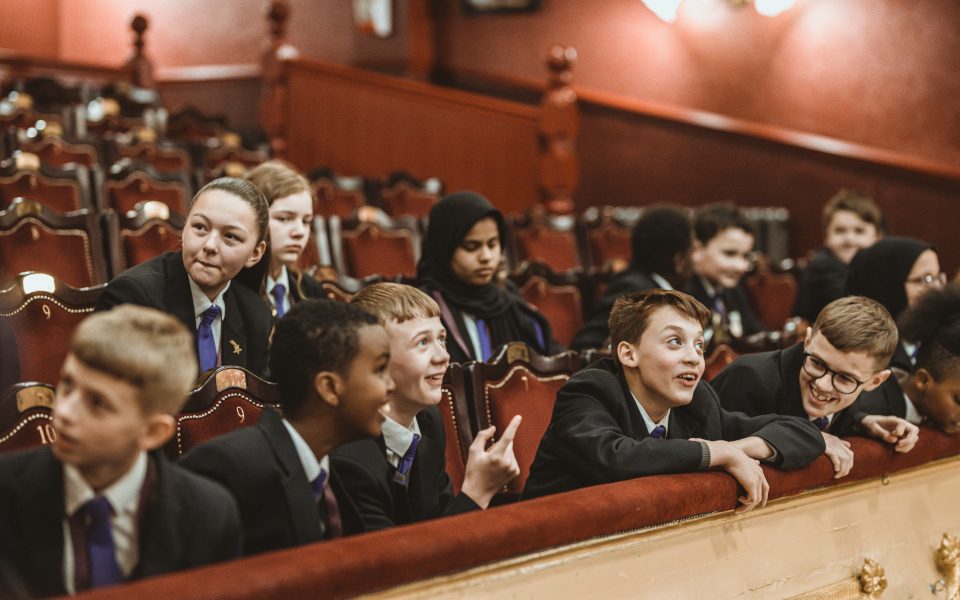 A group of children in uniform sitting in the City Varieties Auditorium