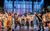 Full company The cast of Fisherman's Friends playing music and singing with arms in the air