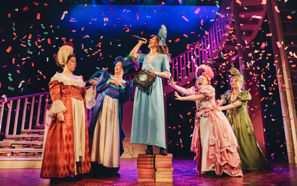 Women in regency style costumes singing and dancing surrounded by confetti