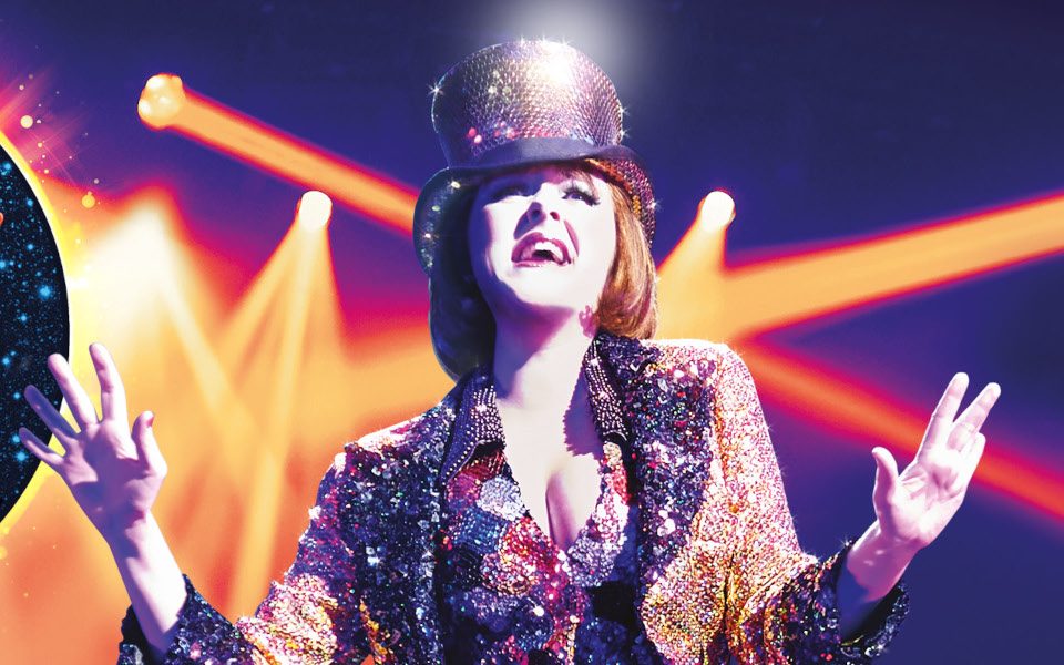 A woman in a sparkly jacket and top hat