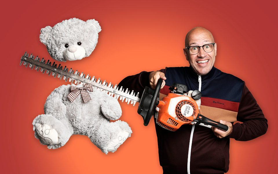 Sam Avery smiling with a chainsaw and cutting the head of a teddy bear