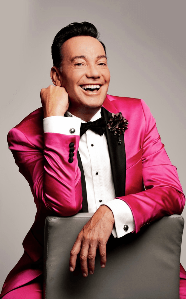 A portrait of Craig Revel Horwood in a pink suit