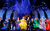 Strictly Ballroom Dancers in brightly coloured costumes in front of a blue backdrop