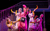 Pride and Prejudice* (*sort of) A group of five women in Regency-period costumes wearing rubber gloves and singing into microphones. Two kneel down and two stand facing opposite directions so they are in a popstar formation.