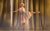 Dominique Larose Dominique Larose as Daisy Buchanan in a white 1920s dress and curled blonde hair. She stands on pointe on one leg in a ballet pose.