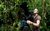 Gordon Buchanan Gordon Buchanan looking up and focusing a large film camera in the middle of a jungle