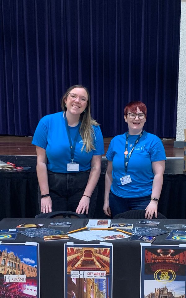 Sarah and Imogen from the Learning and Engagement team stand behind a stall at a Careers Fair.