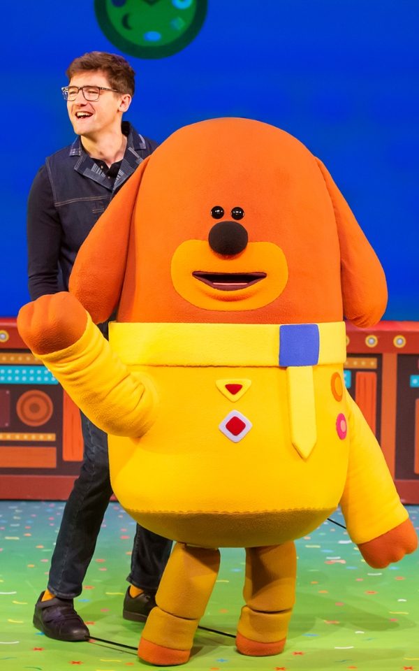 A large puppet of Duggee from Hey Duggee with puppeteer Benedict Hastings