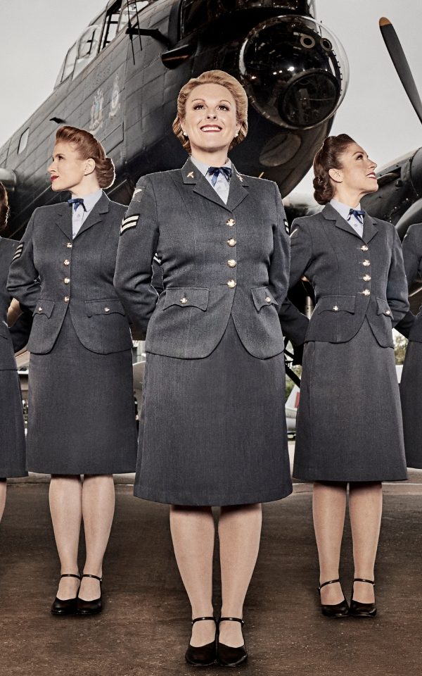 Katie Ashby and two of the D-Day Darlings in 1940s Women's RAF uniforms with a Lancaster Bomber plane behind them.