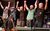 Lindisfarne: Magic in the Air Members of Lindisfarne are standing on stage in the process of bowing at the end of a show. They are holding hands with all of their arms raised.