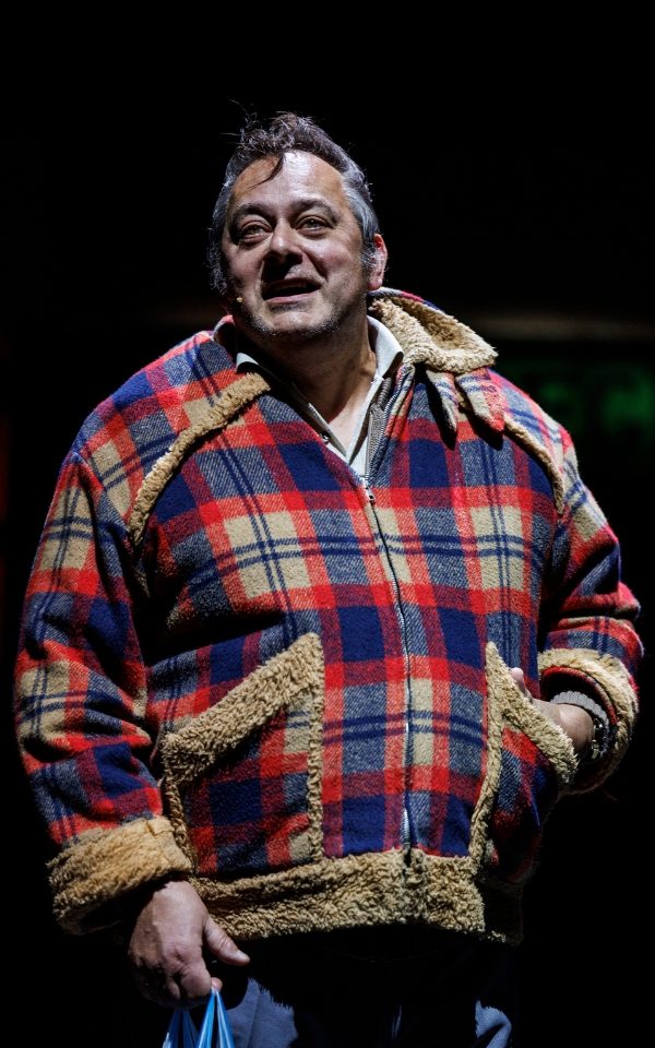 Nigel Pivaro as Da in a red and blue check jacket