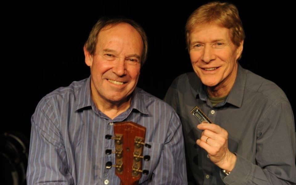 Paul Jones & Dave Kelly holding an acoustic guitar and a harmonica.