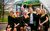 Calendar Girls the Musical The 2018 cast of Calendar Girls the Musical with Gary Barlow and Tim Firth in front of a Leeds bus with luggage. They are wearing sunflowers on their green dresses.