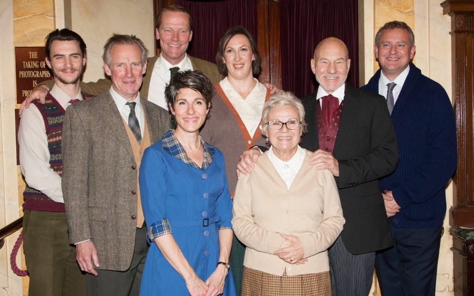 Harry Lloyd, Julie Walters, Patrick Stewart, Iain Glen, Tamsin Greig, Nicholas Farrell, Hugh Bonneville and Miranda Hart smiling at the camera in their 1950s costumes from The Mousetrap.