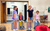 Play in a Week rehearsals Four children are performing a poem in front of their peers in the studio. Two are standing, two are sitting on chairs.