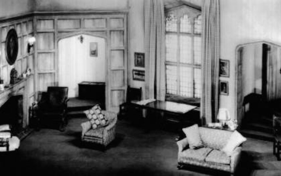 Black and white photo of the original set of The Mousetrap. It is an old fashioned sitting room with a large window