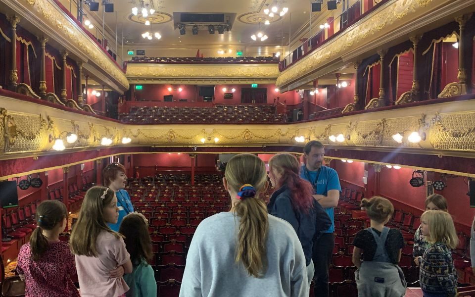 Young people on stage at City Varieties Music Hall, looking out into an empty auditorium. Credit: Kate Southam