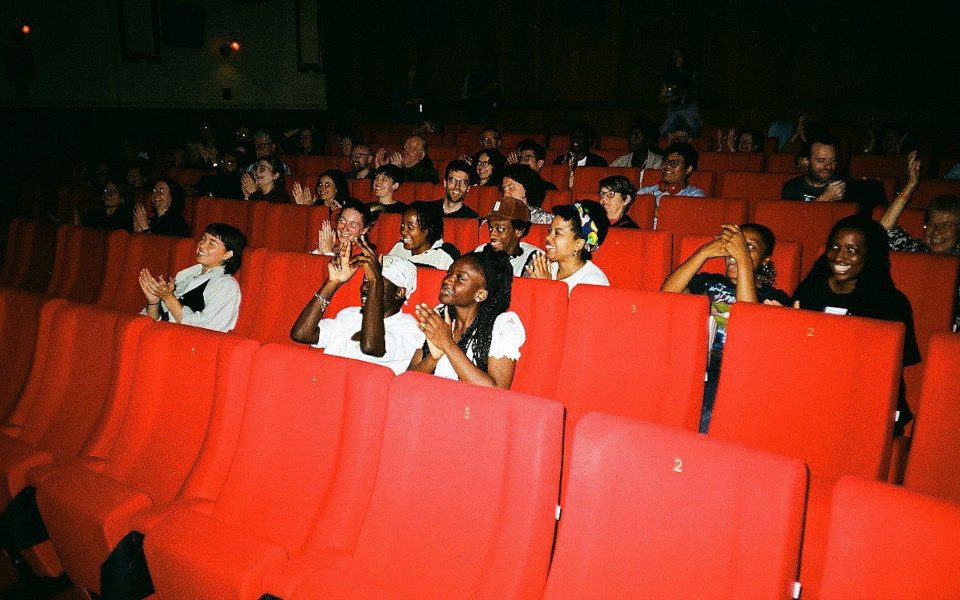 A screening at The Picture House with a happy audience. They are smiling and clapping.