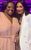 Judi Love Judi Love is wearing a pink jumpsuit and standing next to Nicole Scherzinger who is wearing a white suit.