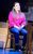 The Greatest Days Kym Marsh is wearing a pink jumper and sitting on a chair.