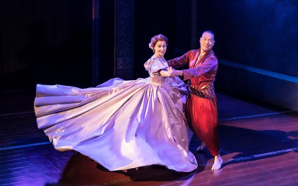 Annalene Beechey in a lilac ballgown and Darren Lee in a traditional Thai costume dancing together.