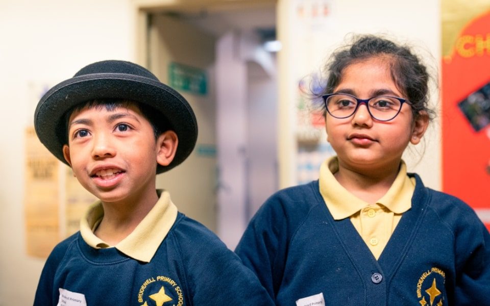 A pair of primary school children dressed up in historical props during a workshop
