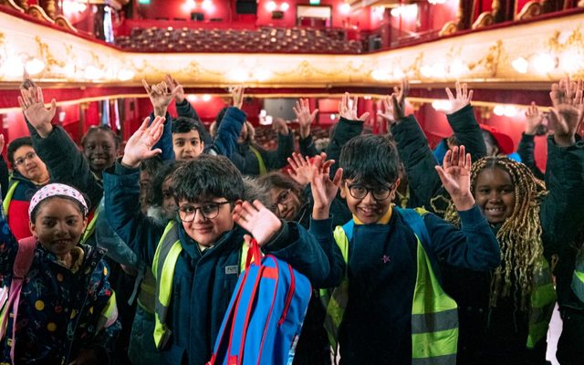 Primary Tour. Credit Chris Coote A group of primary schoolchildren pose on stage at City Varieties Music Hall with the auditorium in the background