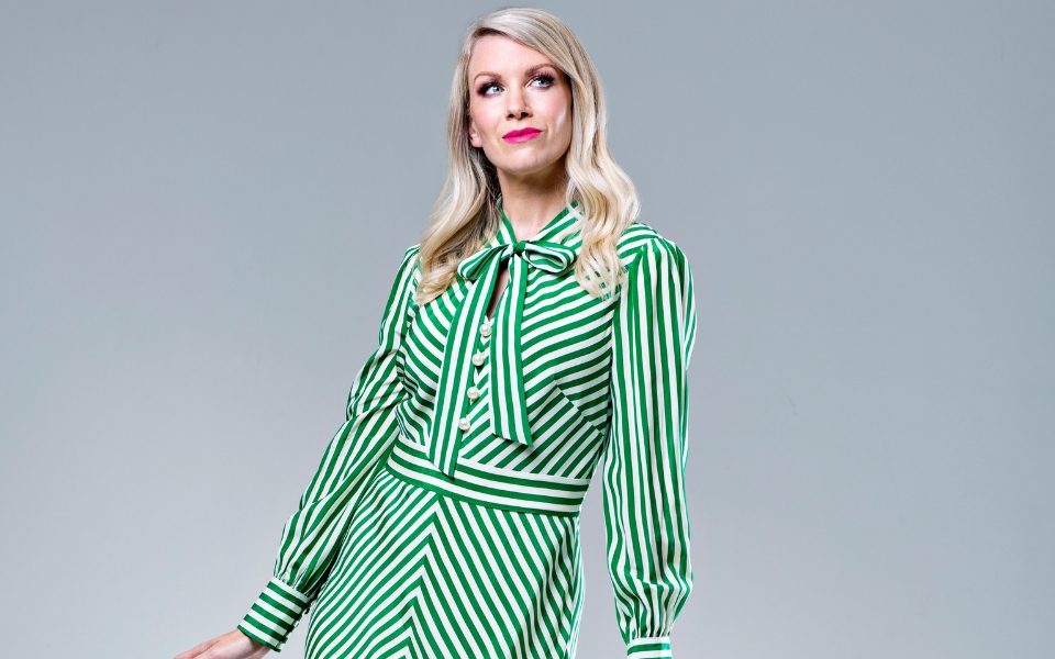 Rachel Parris in a green striped dress looking off to the side