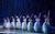 Norther Ballet's The Nutcracker (2022) A row of dancers pose together, arms outstretched against the backdrop of a forest.