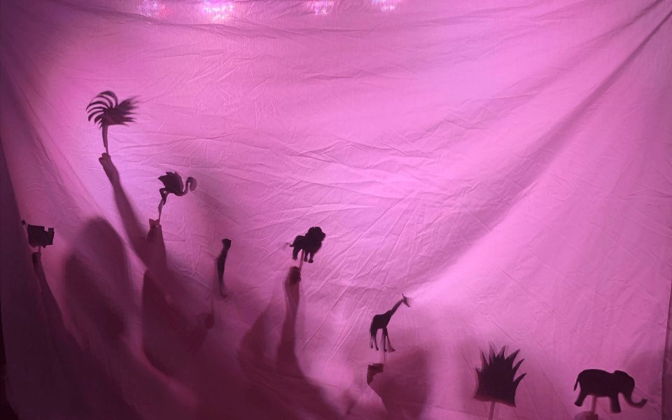Shadows from shadow puppets on a white cloth.