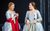 Cosi fan tutte Helen Sherman as Dorabella and Máire Flavin as Fiordiligi look at each other wearing grey 18th century dresses. Dorabella has a bright red scarf over her arms.