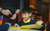 Pupil with yellow paper. Credit Ollie Jenkins A primary schoolchild sits smiling at a desk with a piece of yellow paper