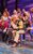 Come From Away Two actors passionately kissing on stage. She's grabbing his green and yellow varsity jacket. They're surrounded by an excited-looking group of people and musicians with violins.