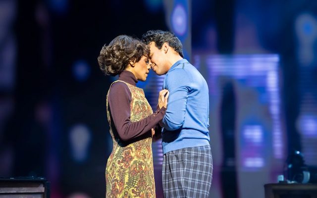 Elle Ma-Kinga N'Zuzi as Tina and Kyle Richardson as Raymond Hill (Credit: Johan Persson) Elle Ma-Kinga N'Zuzi as Tina and Kyle Richardson as Raymond Hill sharing an embrace on stage.