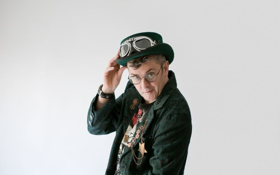 Joe Pasquale in steam punk attire looking straight at the camera.