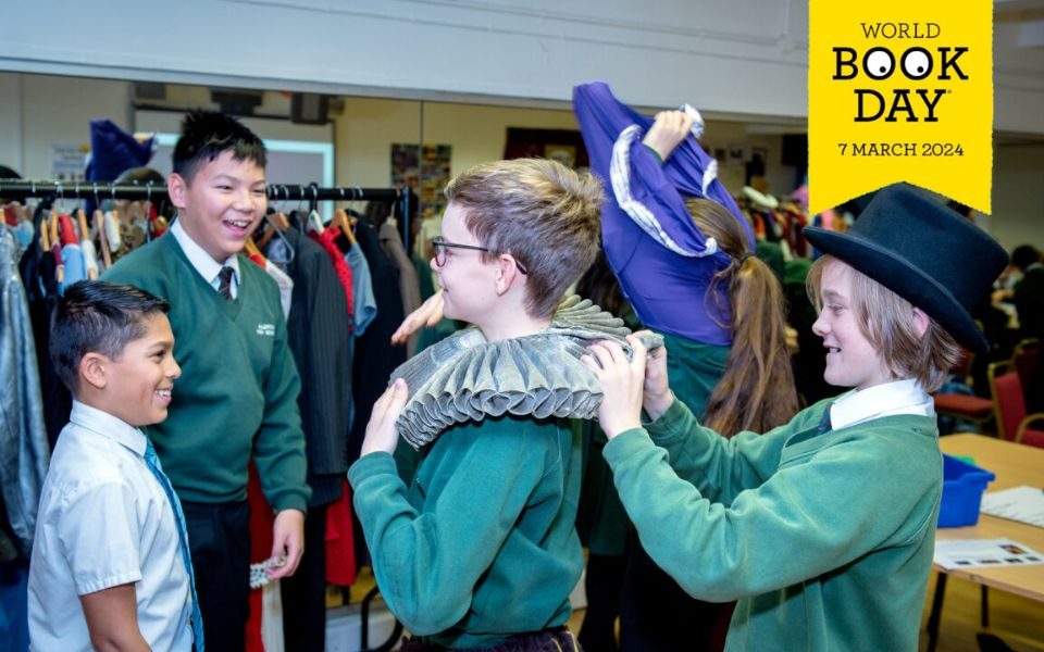 Students dress each other up in period costumes. The yellow World Book Day logo is in the top right corner.