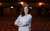 Lizi Patch. Credit Kerry Maule A smiling woman with brown hair and her arms crossed looks into the camera against the backdrop of Leeds Grand Theatre auditorium