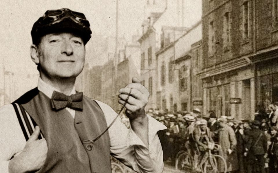Sepia-toned photograph of Ned Boulting in 1920s dress including a waistcoat, bow tie and flat cap photoshopped into an actual 1920s street photo featuring someone on a bike.