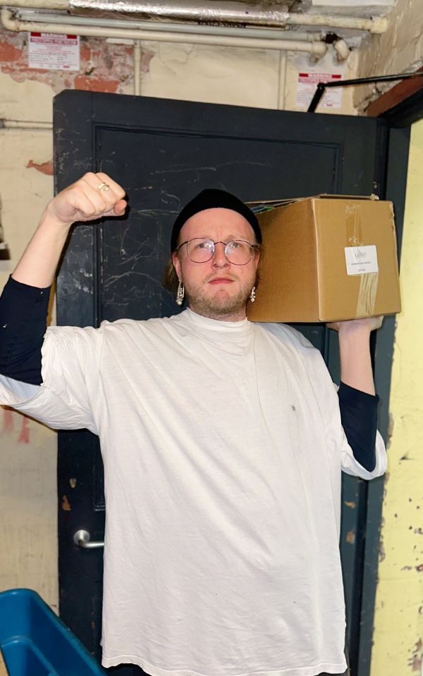 Henry holds a cardboard box and shows off his muscle.